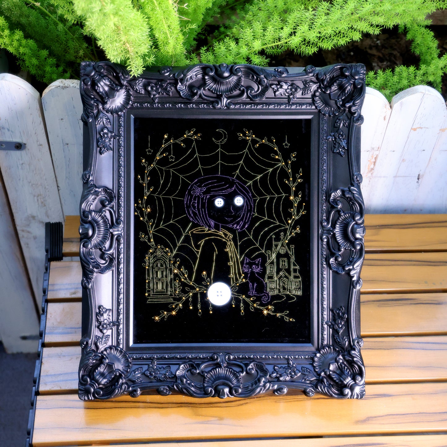10 inches Original Coraline-themed embroidered wall art on black velvet with metallic thread, rhinestones, and button eyes in an ornate black frame. Handmade, ready to hang. Contains handmade embroidered decorative paintings.