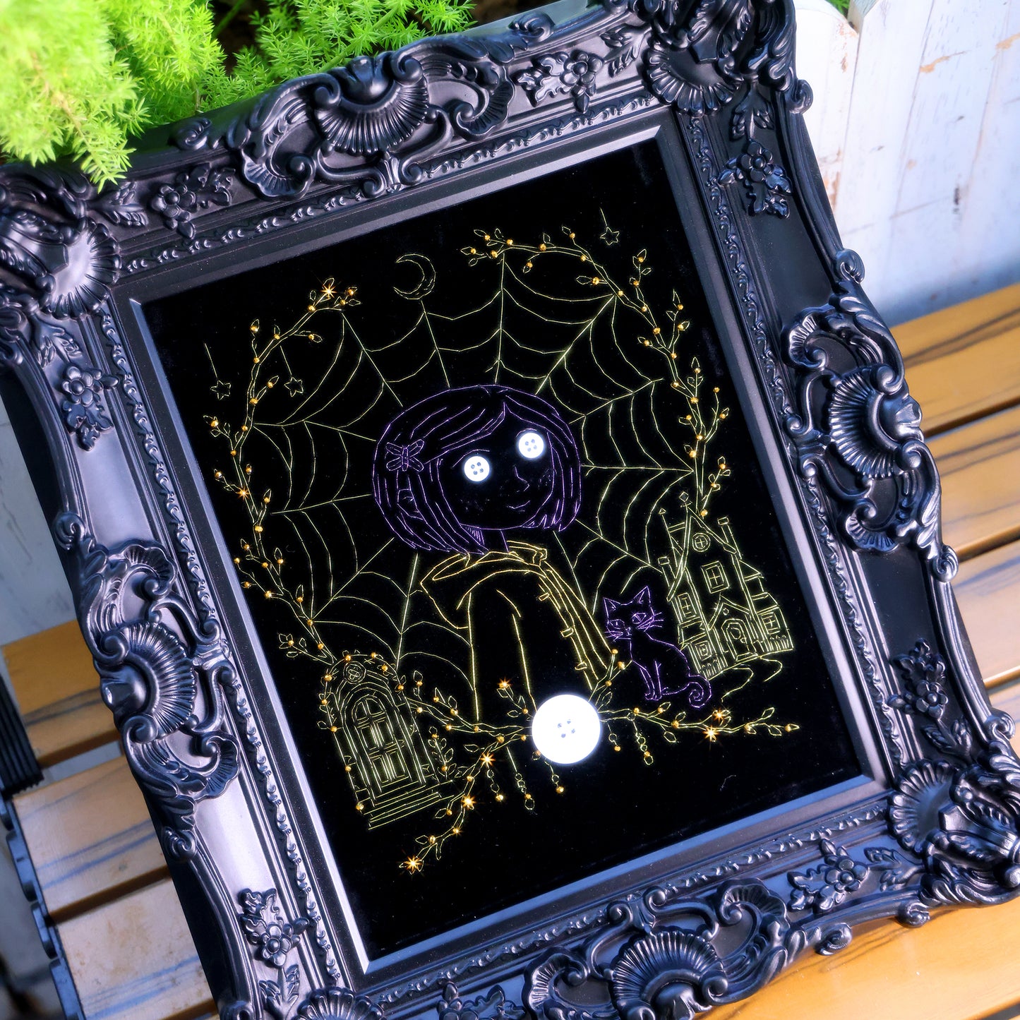 10 inches Original Coraline-themed embroidered wall art on black velvet with metallic thread, rhinestones, and button eyes in an ornate black frame. Handmade, ready to hang. Contains handmade embroidered decorative paintings.