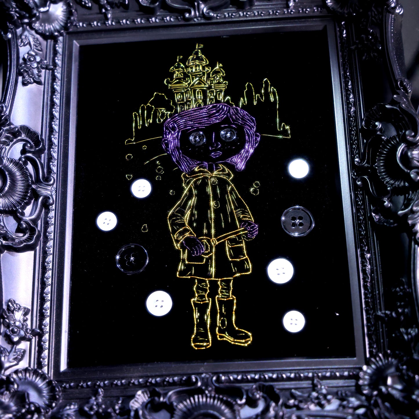 8 inches Handmade Coraline-inspired embroidered wall art on black velvet with metallic thread, buttons, and rhinestone accents in a matte ornate black frame — intentionally unglazed to showcase texture. Contains handmade embroidered decorative paintings.