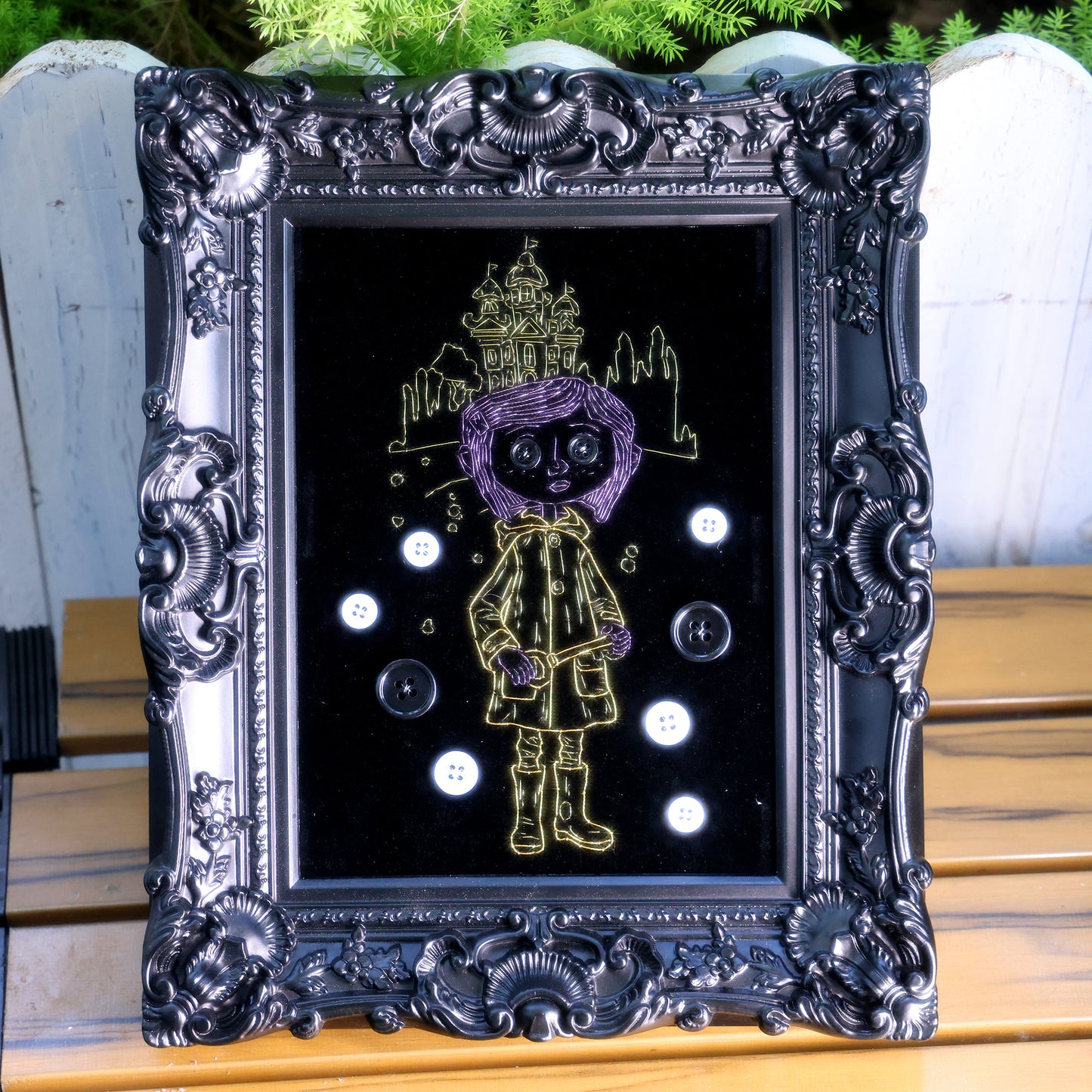 8 inches Handmade Coraline-inspired embroidered wall art on black velvet with metallic thread, buttons, and rhinestone accents in a matte ornate black frame — intentionally unglazed to showcase texture. Contains handmade embroidered decorative paintings.